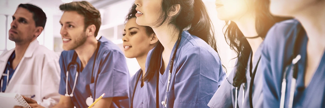 Medical students listening sitting at desk